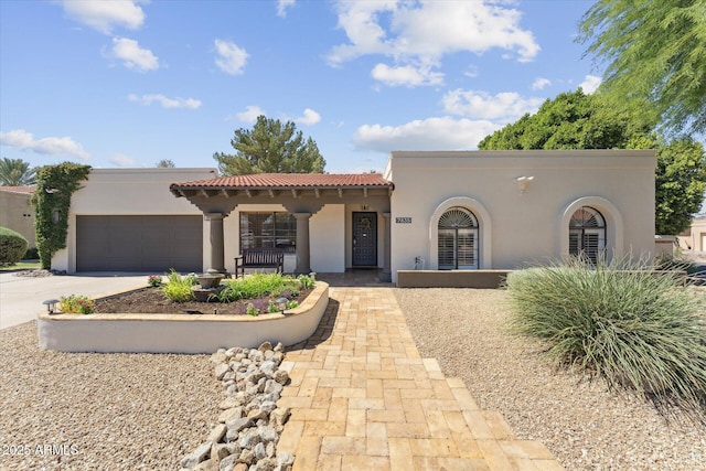 7835 E Cannon Dr, Scottsdale, AZ 85258 - mediterranean / spanish home with stucco siding, a tiled roof, an attached garage, and driveway