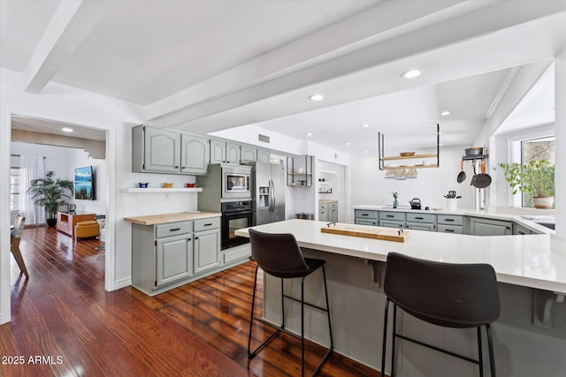 7835 E Cannon Dr, Scottsdale, AZ 85258 - kitchen featuring stainless steel appliances, gray cabinets, a peninsula, dark wood-type flooring, and recessed lighting