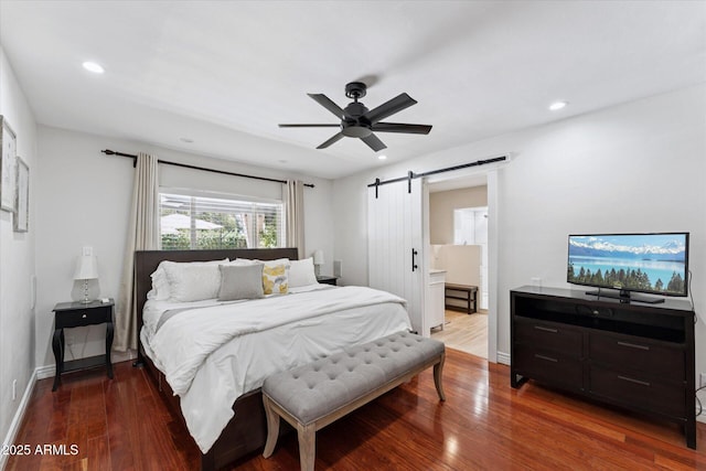 7835 E Cannon Dr, Scottsdale, AZ 85258 - bedroom with a barn door, wood finished floors, recessed lighting, ceiling fan, and ensuite bathroom