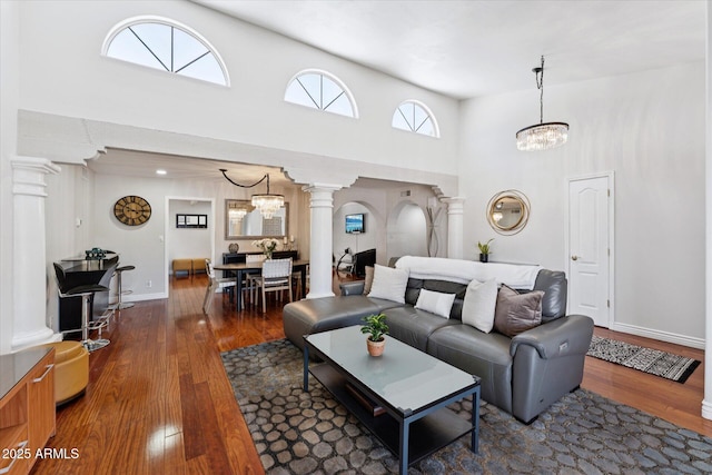 7835 E Cannon Dr, Scottsdale, AZ 85258 - living area with decorative columns, a towering ceiling, hardwood / wood-style floors, and a chandelier