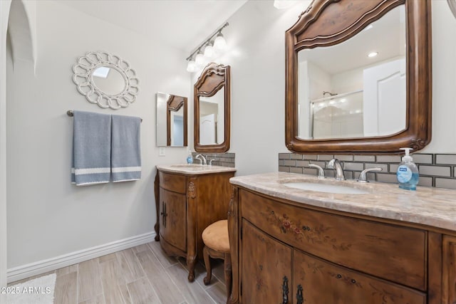 7835 E Cannon Dr, Scottsdale, AZ 85258 - full bathroom featuring two vanities, decorative backsplash, a shower, and wood finished floors