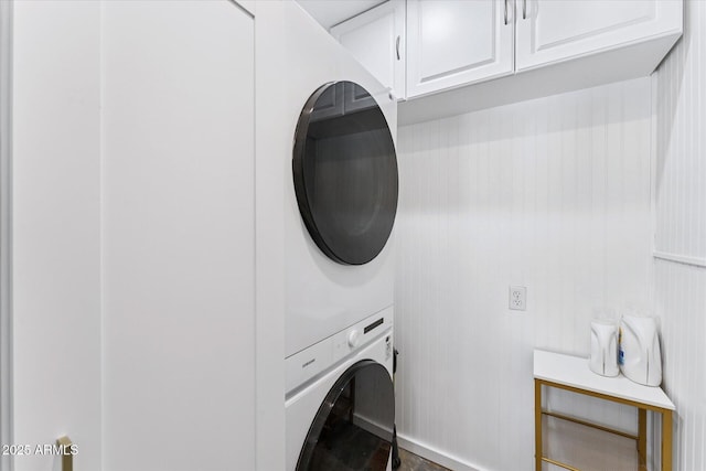 7835 E Cannon Dr, Scottsdale, AZ 85258 - laundry room featuring stacked washing machine and dryer, cabinet space, and wood finished floors