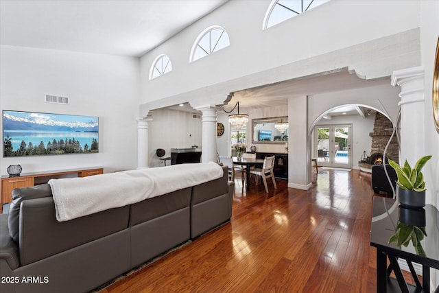 7835 E Cannon Dr, Scottsdale, AZ 85258 - living area featuring decorative columns, hardwood / wood-style flooring, arched walkways, and a towering ceiling