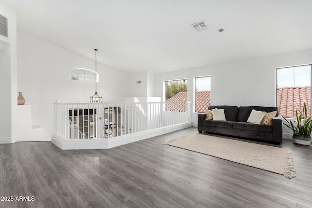 living room featuring vaulted ceiling, hardwood / wood-style floors, and a notable chandelier