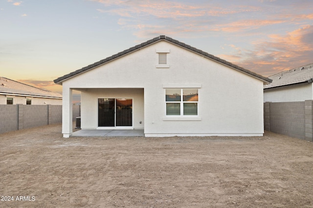 back house at dusk with a patio