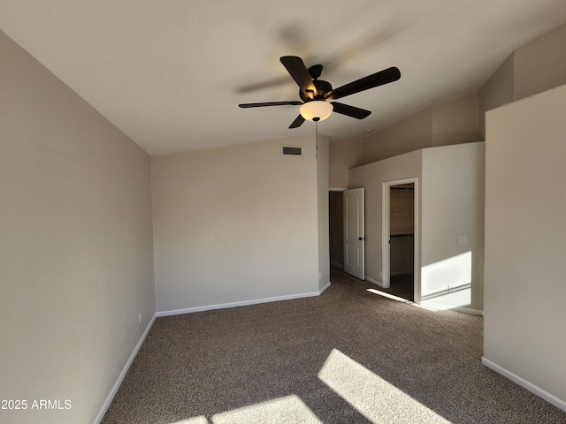 unfurnished room with dark carpet, vaulted ceiling, and ceiling fan