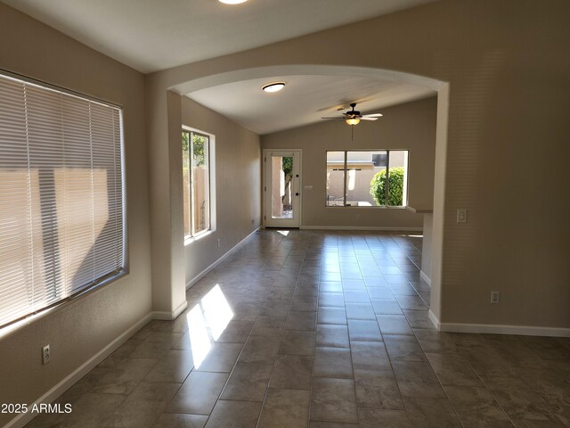 tiled empty room with lofted ceiling and ceiling fan