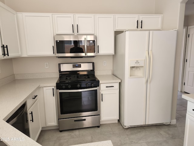 kitchen with white cabinetry, light stone counters, stainless steel appliances, and light tile patterned flooring