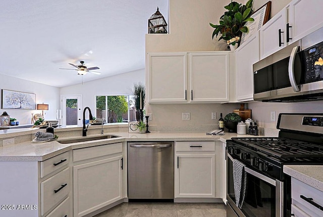 kitchen with sink, vaulted ceiling, stainless steel appliances, and white cabinets