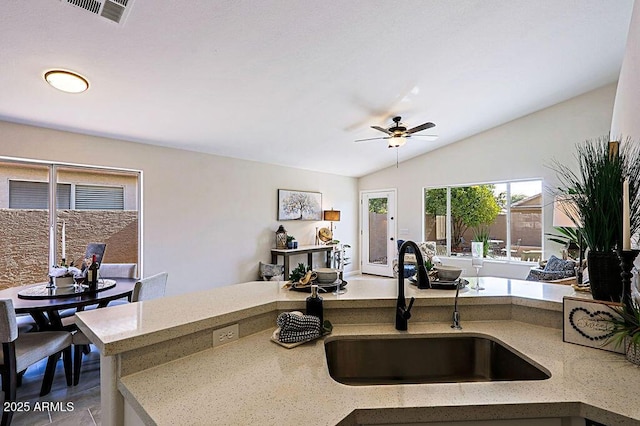 kitchen featuring vaulted ceiling, ceiling fan, tile patterned flooring, and sink