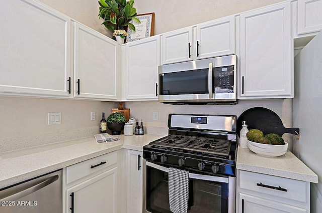 kitchen featuring white cabinetry, stainless steel appliances, and light stone counters