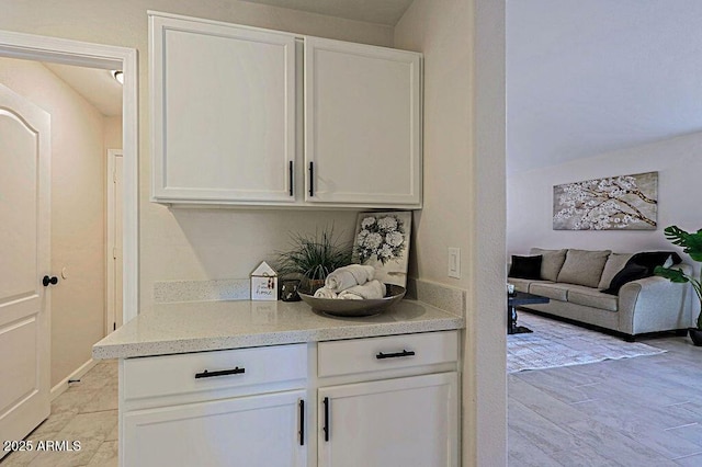 bar featuring white cabinetry and light tile patterned floors