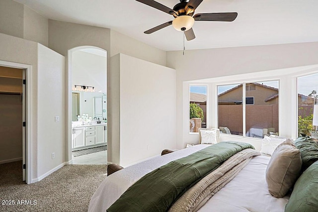 bedroom featuring ensuite bath, ceiling fan, light carpet, a spacious closet, and a closet