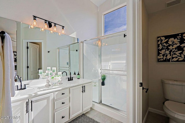 bathroom with a shower with door, vanity, tile patterned flooring, and toilet