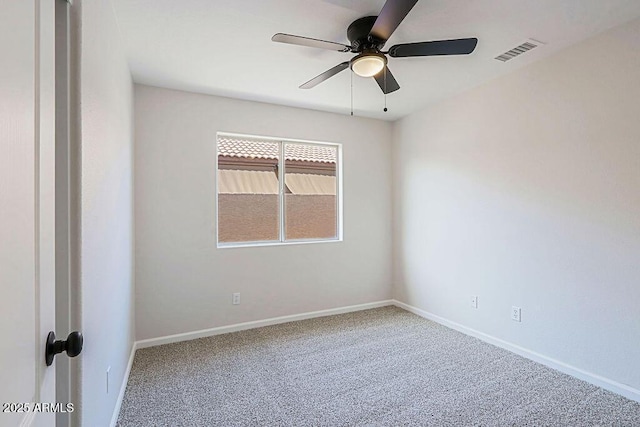 spare room with ceiling fan and carpet