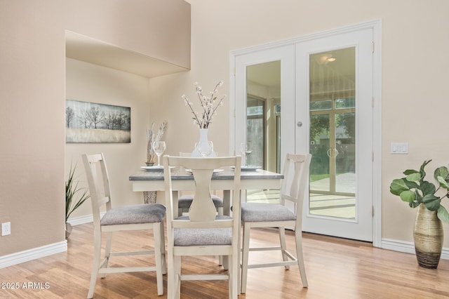 dining space with baseboards, french doors, and wood finished floors