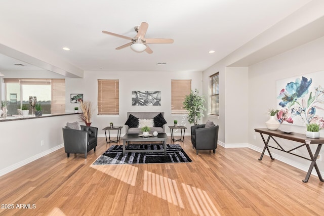 living area with baseboards, wood finished floors, and a wealth of natural light