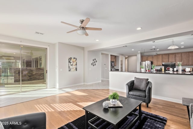 living area featuring a ceiling fan, visible vents, recessed lighting, and light wood finished floors