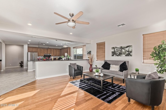 living room with a ceiling fan, visible vents, baseboards, light wood-style floors, and recessed lighting