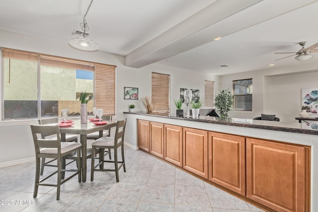 interior space featuring baseboards, ceiling fan, light tile patterned floors, and visible vents