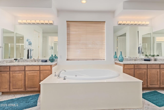 full bath featuring tile patterned flooring, a sink, a garden tub, and two vanities