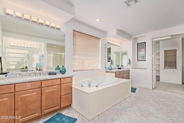 bathroom featuring a sink, tile patterned floors, a shower stall, visible vents, and a garden tub