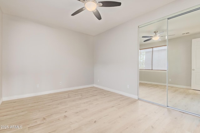 unfurnished bedroom featuring a closet, baseboards, wood finished floors, and visible vents