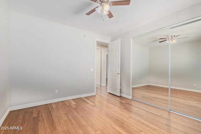 unfurnished bedroom featuring a closet, baseboards, ceiling fan, and light wood-style floors