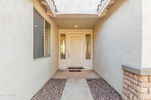 doorway to property featuring stucco siding