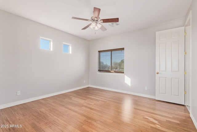unfurnished room with baseboards, ceiling fan, and light wood-style flooring