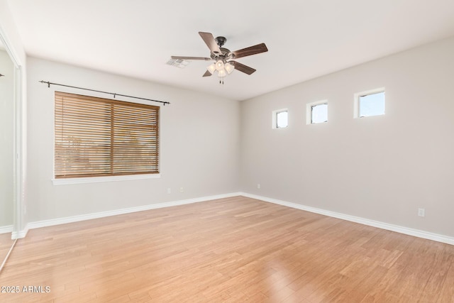 spare room featuring ceiling fan, visible vents, baseboards, and light wood-style floors