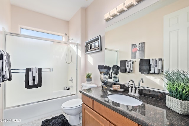 full bath featuring vanity, bath / shower combo with glass door, and toilet