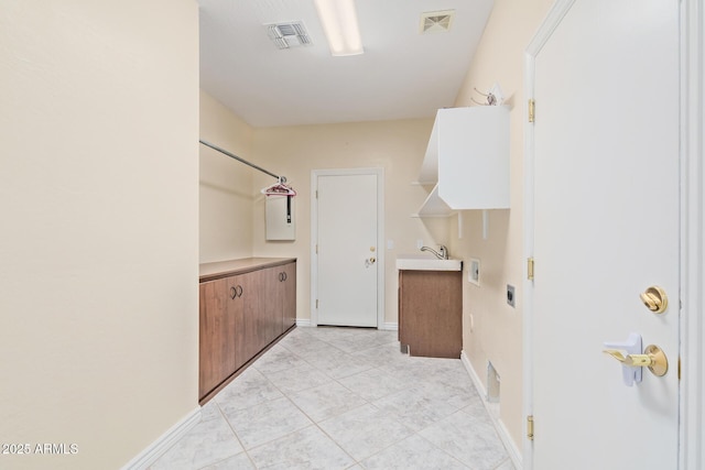 washroom with light tile patterned floors, baseboards, laundry area, and visible vents