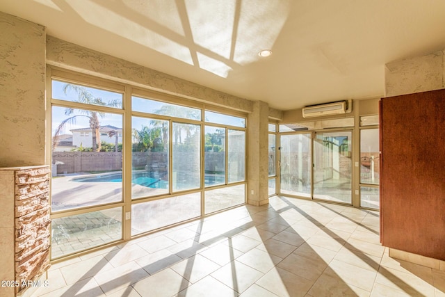 unfurnished sunroom with recessed lighting, a wall unit AC, and tile patterned flooring