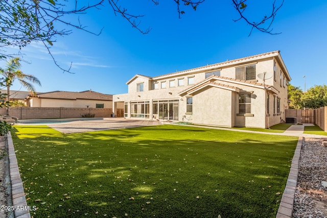 rear view of property featuring stucco siding, a fenced backyard, a fenced in pool, a lawn, and a patio