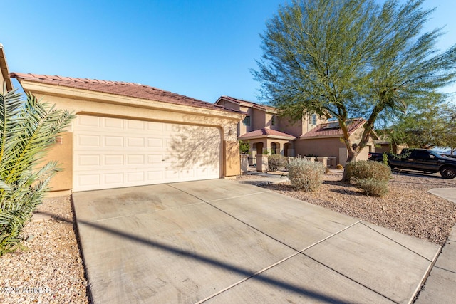 45 S 238th Dr, Buckeye, AZ 85396 - mediterranean / spanish house featuring a garage, driveway, a tiled roof, and stucco siding
