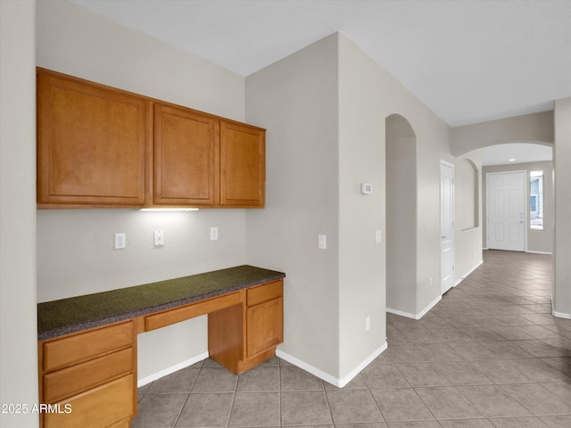 kitchen featuring built in desk and light tile patterned floors