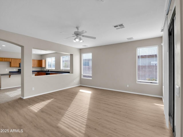 interior space with ceiling fan, a healthy amount of sunlight, sink, and light hardwood / wood-style flooring