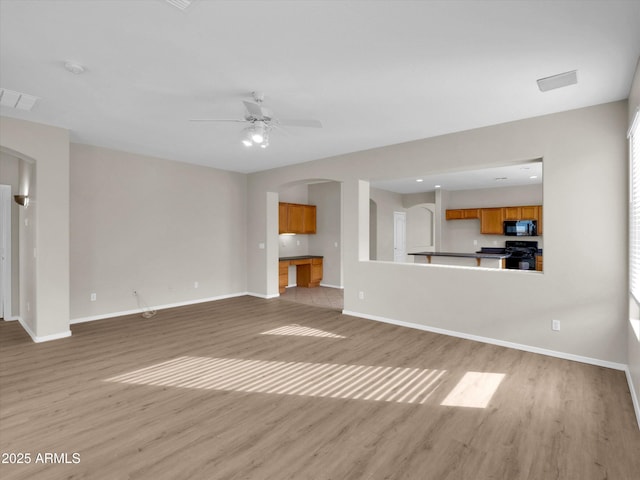 unfurnished living room with ceiling fan and light wood-type flooring