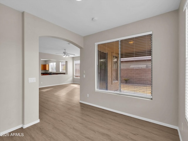 empty room with hardwood / wood-style floors and ceiling fan