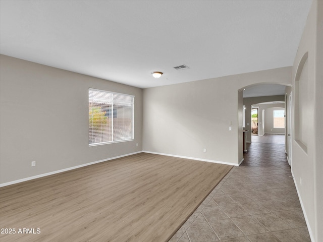 tiled spare room featuring a healthy amount of sunlight