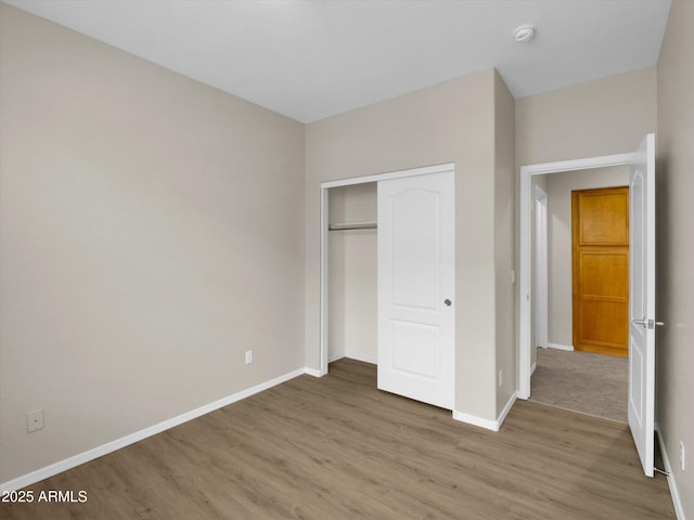 unfurnished bedroom with hardwood / wood-style flooring and a closet