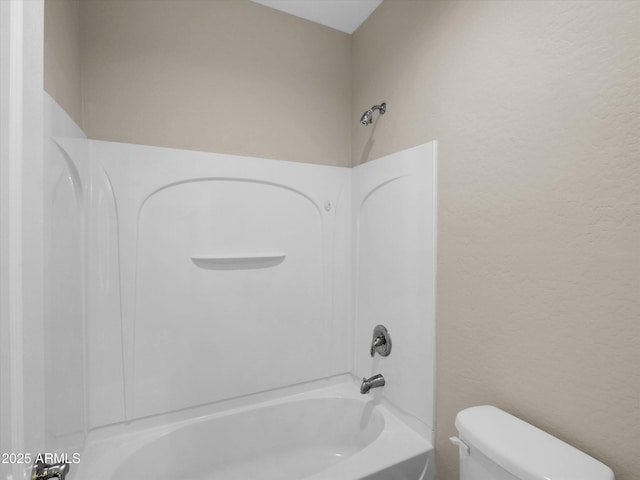 bathroom featuring bathtub / shower combination and toilet