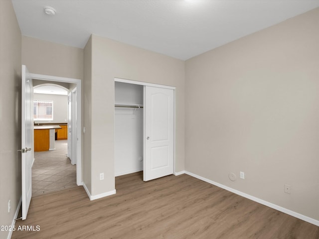 unfurnished bedroom with light hardwood / wood-style floors and a closet