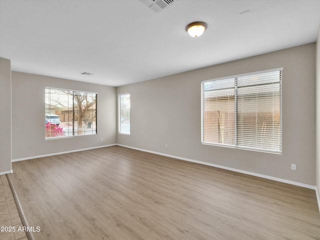 unfurnished room with light wood-type flooring and a healthy amount of sunlight