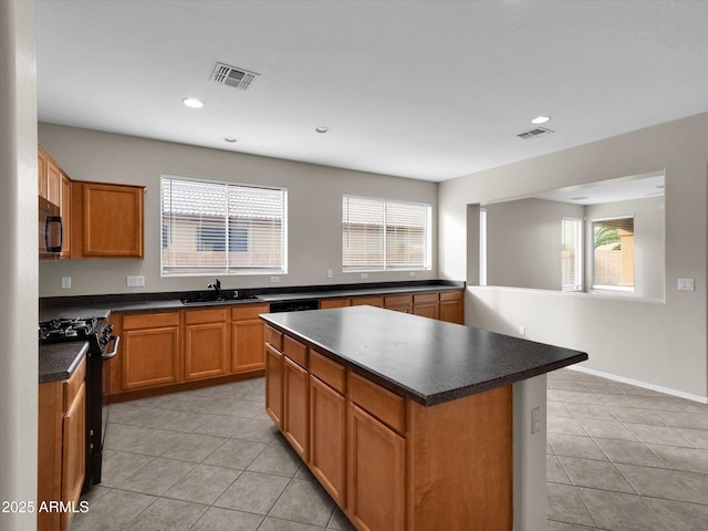 kitchen with a center island, sink, black range, and plenty of natural light