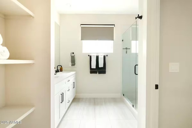 bathroom featuring a shower with shower door and vanity