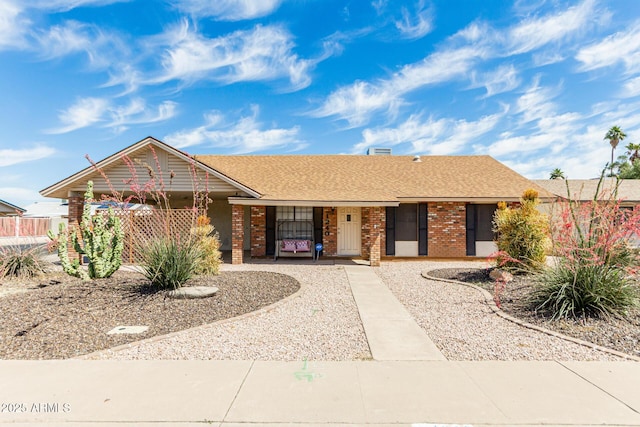 1240 E Indigo St, Mesa, AZ 85203 - ranch-style house featuring a porch, brick siding, fence, and a shingled roof