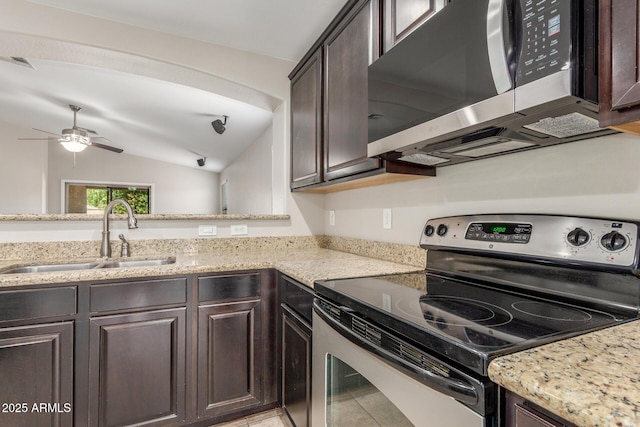 kitchen featuring a sink, dark brown cabinetry, stainless steel appliances, light stone countertops, and visible vents