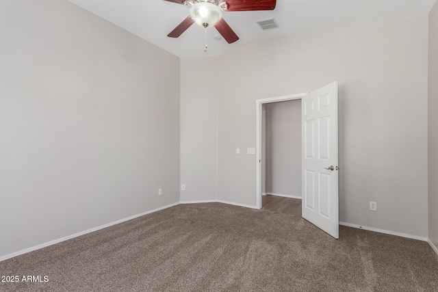 carpeted spare room with ceiling fan, baseboards, and visible vents